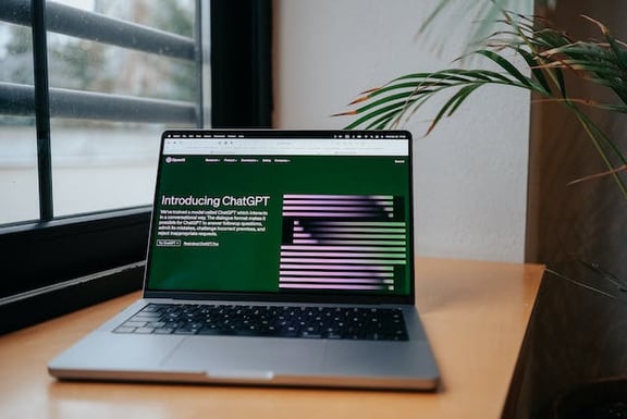 a laptop on a desk in front of a window