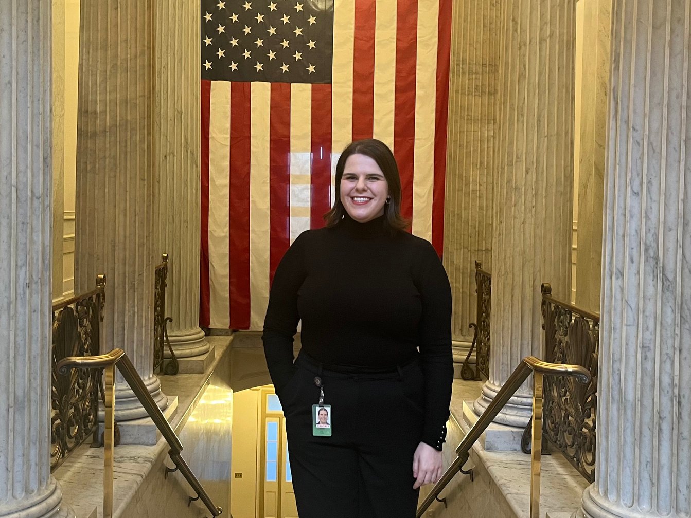 a person standing in front of an American flag