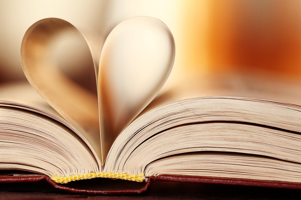 an open book with a heart cut out of it