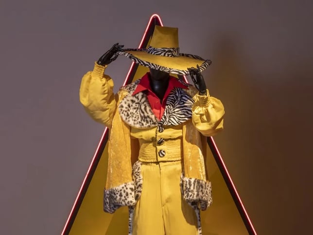 a mannequin dressed in a yellow suit and hat