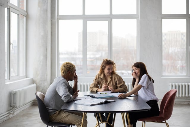 a group of people sitting around a table in an office