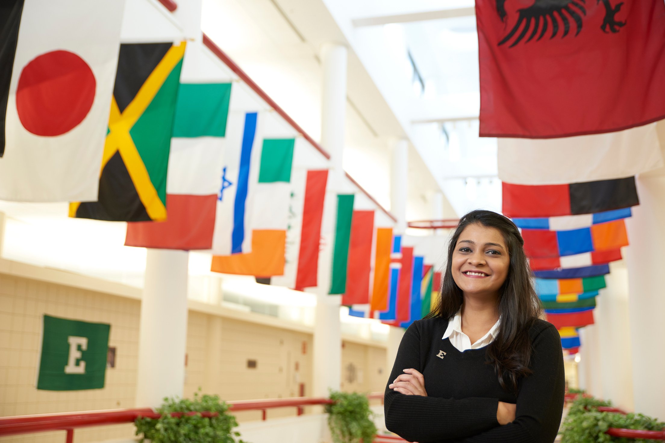 a person standing in front of flags in a hallway