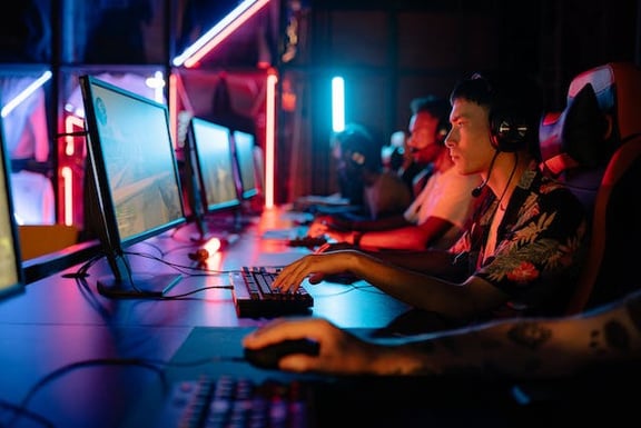 a group of people playing video games in a dark room