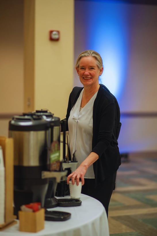 a person standing next to a coffee machine