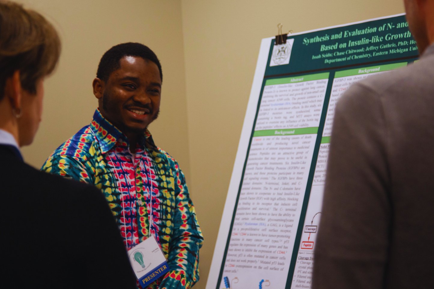 a person in a colorful shirt is standing in front of a poster