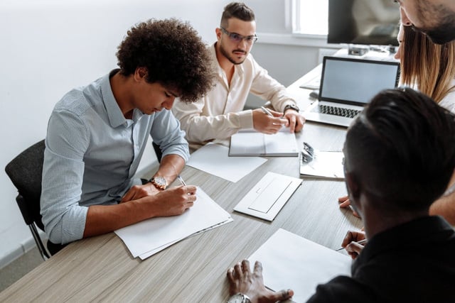 a group of people sitting at a table in an office