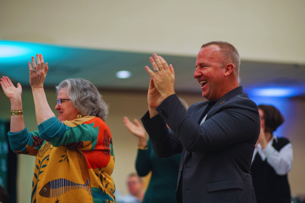 Two people clapping at an event