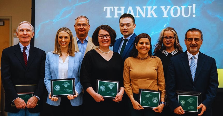 a group of people holding awards in front of a screen