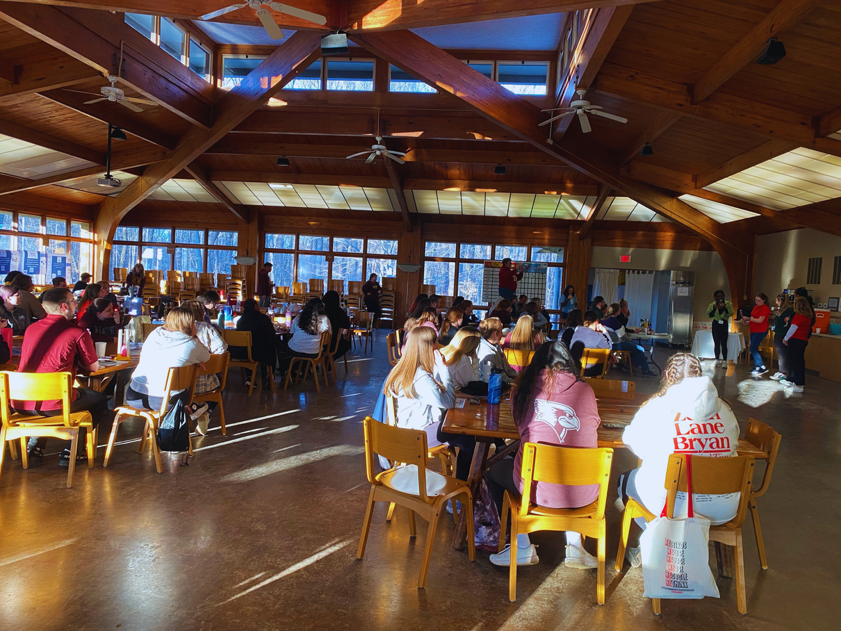 a group of people sitting at tables in a large room