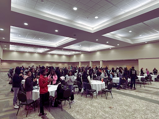 a large group of high school students gathered in a conference room