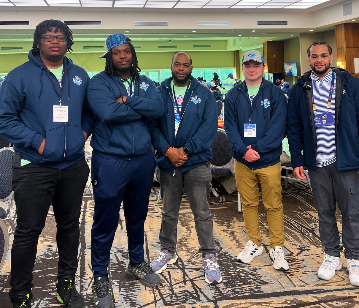 a group of individuals in blue jackets posing for a photo