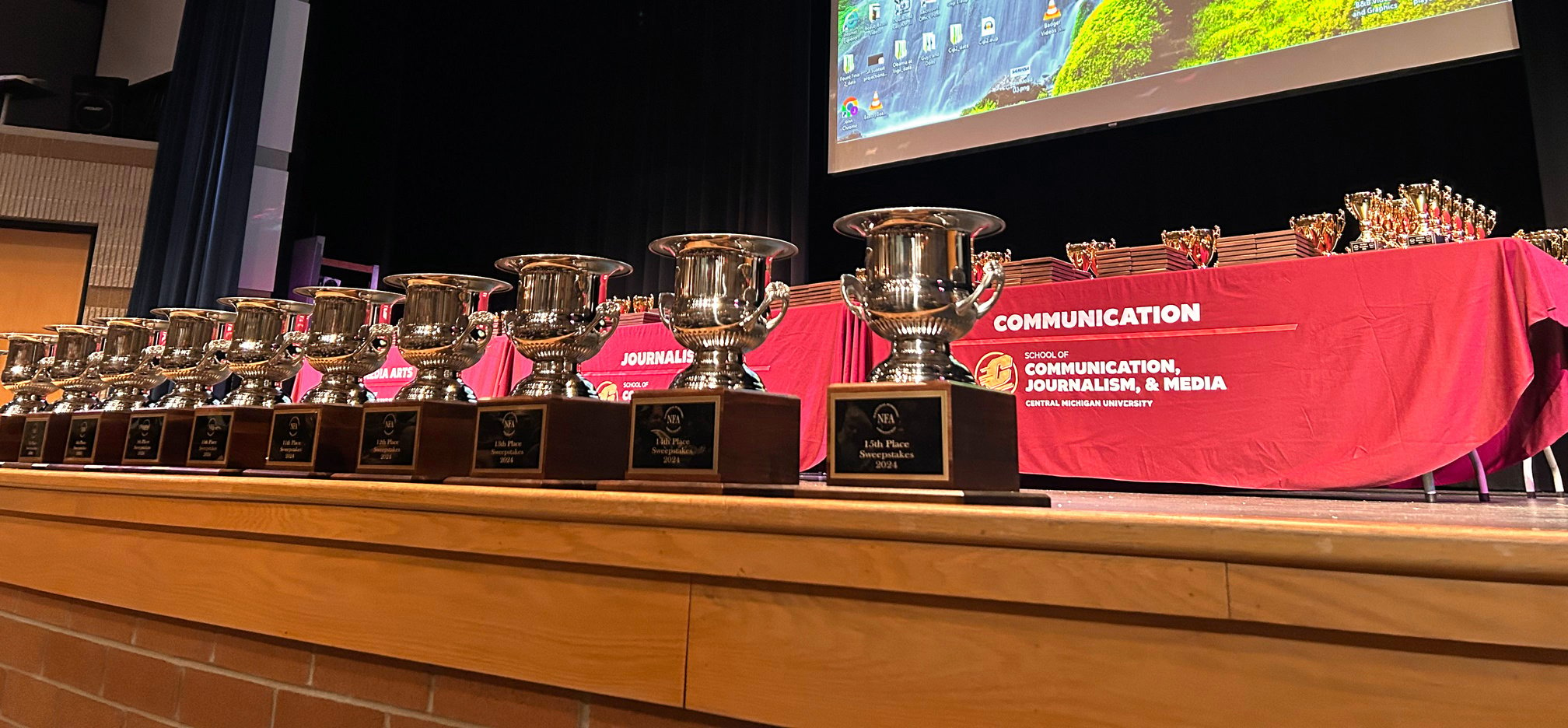 several trophies are lined up on a stage