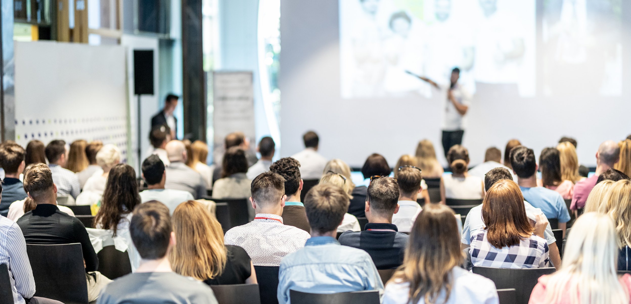 a large group of people sitting in front of a speaker