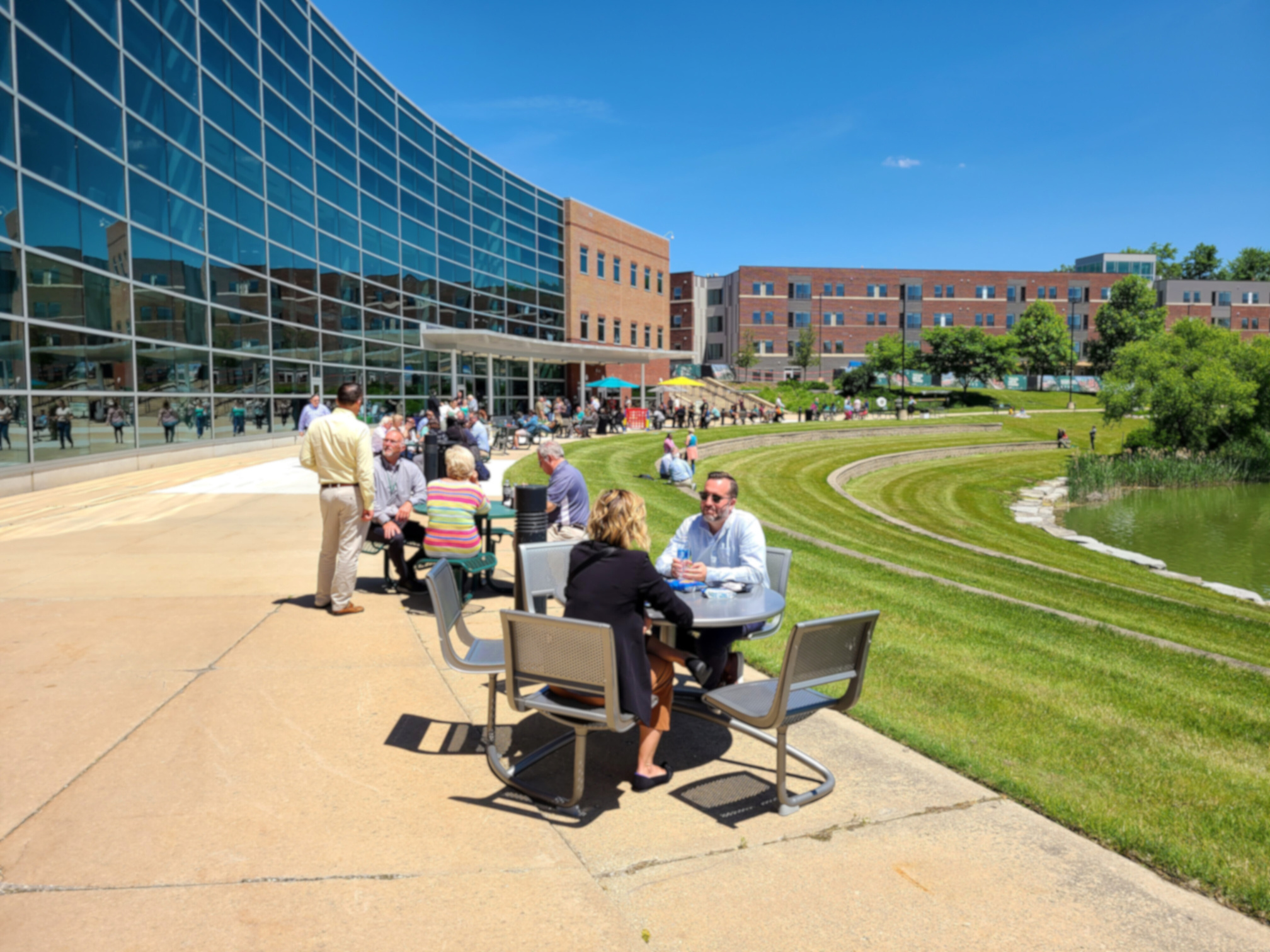 a group of people sitting at tables outside the EMU Student Center