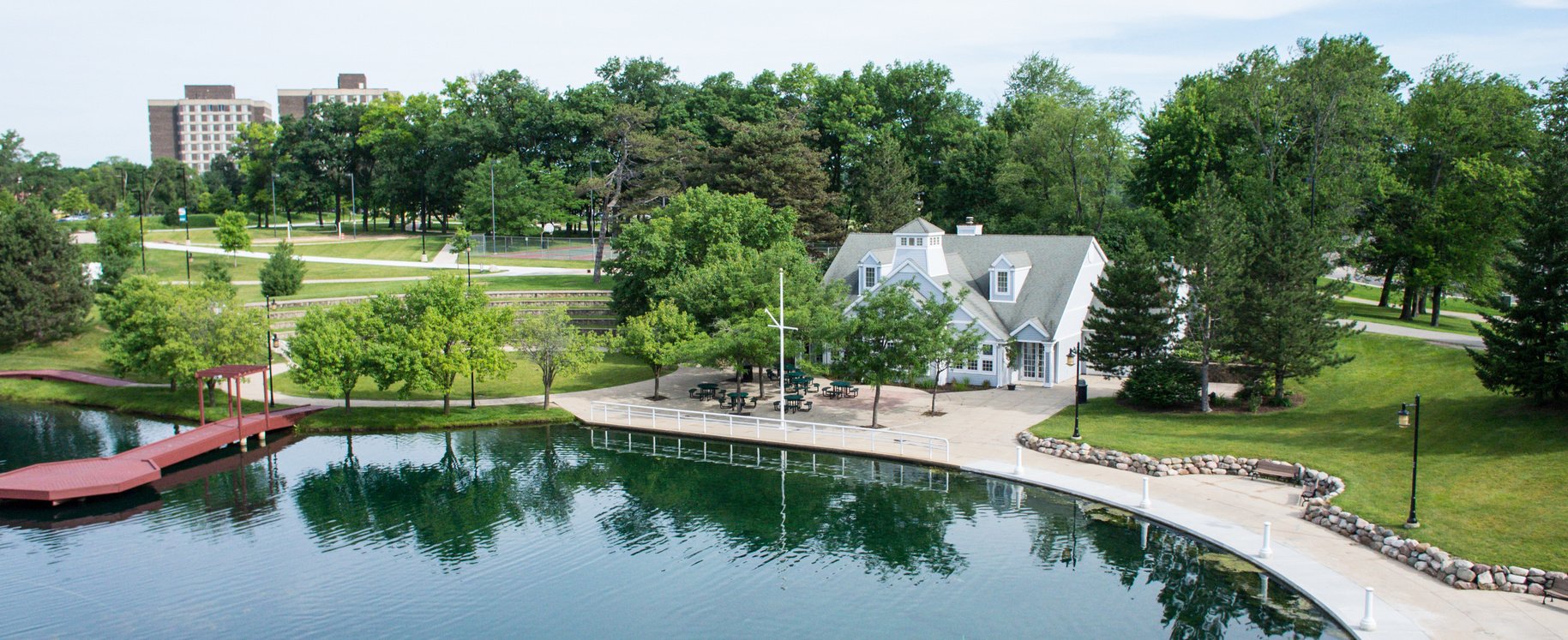 an aerial view of a lake with a house and dock