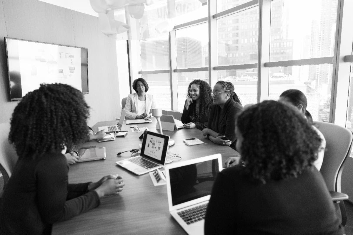 a photo of a group of people sitting around a conference table