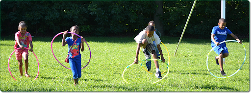 a group of children playing with hula hoops on a grassy field