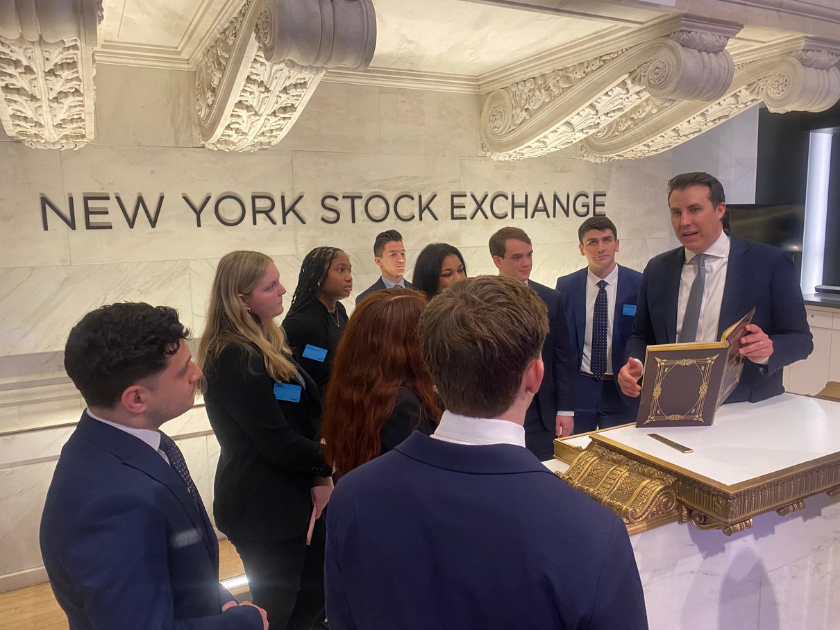 a group of people in suits standing around a table