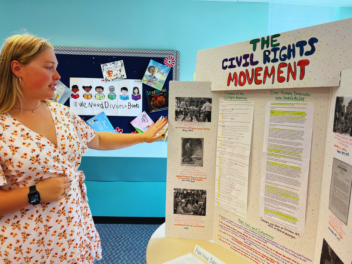 a person is standing in front of a poster with information about the civil rights movement