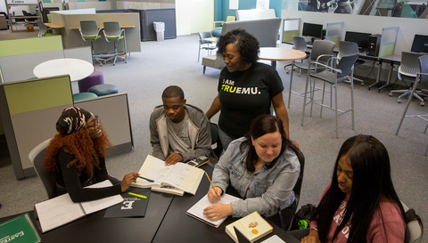 a group of students sitting around a table in an office