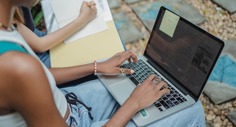 a person sitting on a bench with a laptop