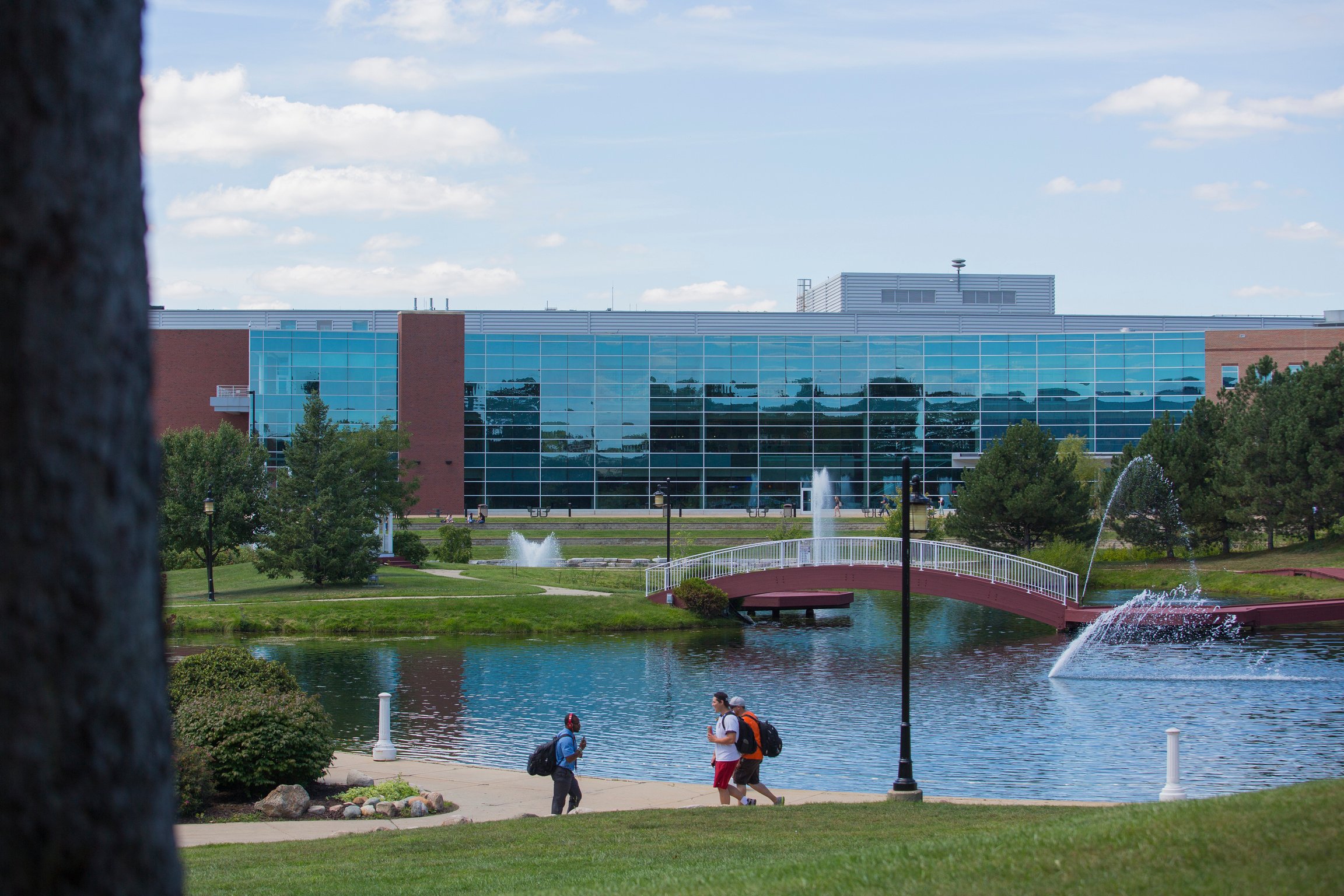 students walk across a bridge in front of the EMU Student Center