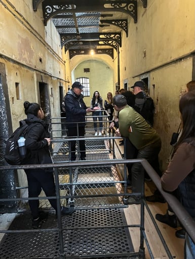 Students speak with facilitators inside a white stone building.