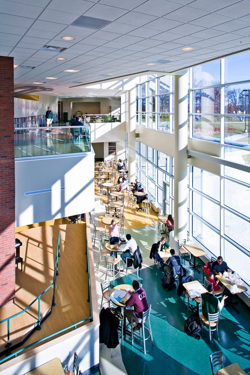 the interior of a large building with many people sitting at tables