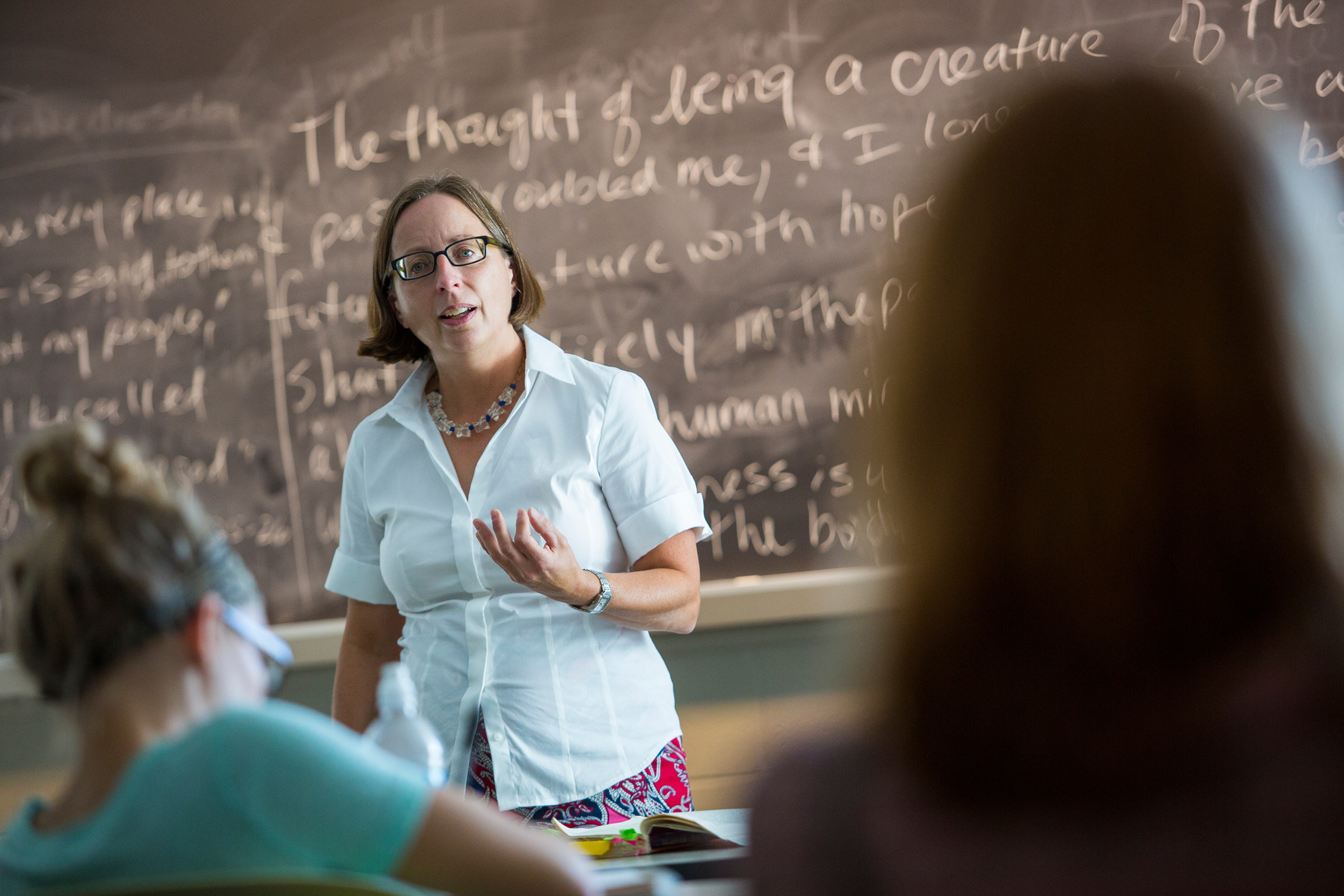 a woman standing in front of a chalkboard