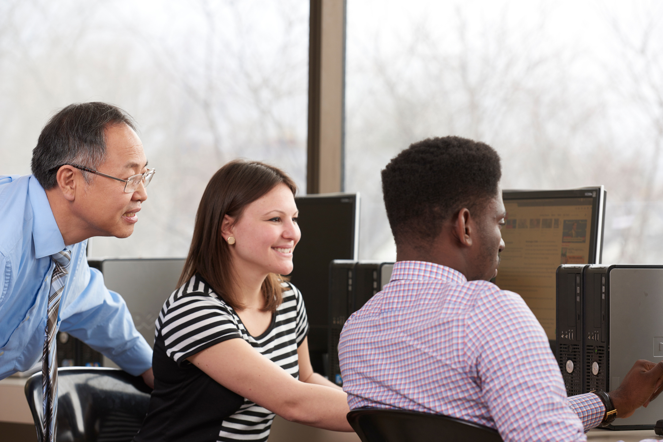 a group of people working on computers in an office