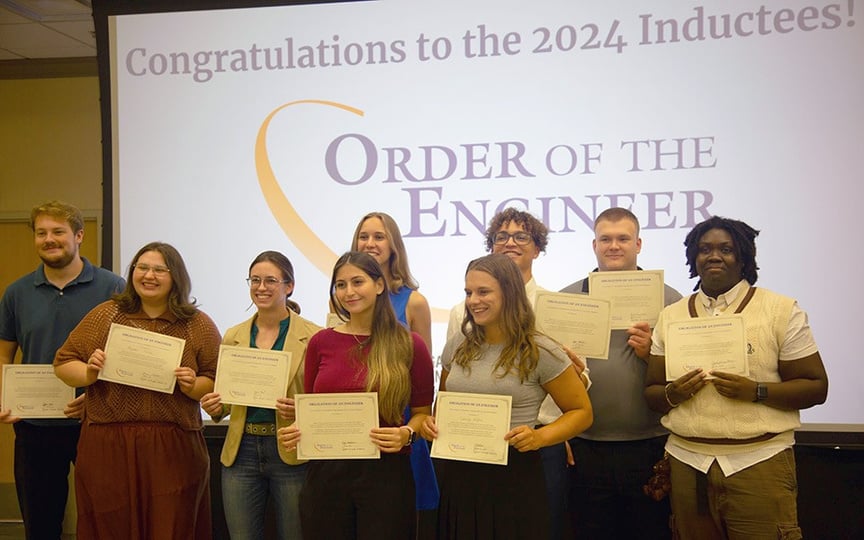 a group of people holding certificates in front of a screen