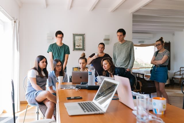 A group of students look at a laptop screen together